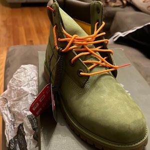 Brand new, in box. Orange laces! Green Tims!